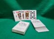 Wedding favours with playing cards featuring a custom venue illustration and the couple's names and date.